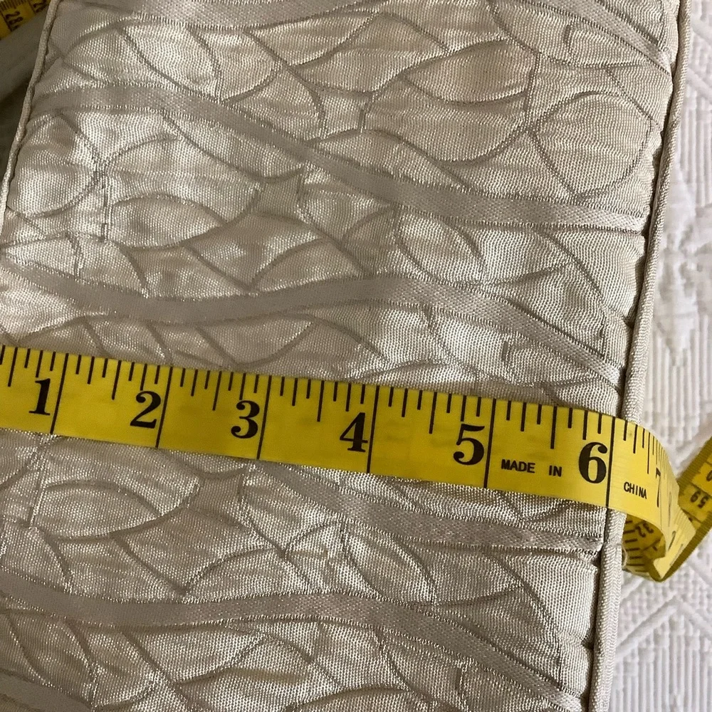 FABRIC SHOULDER BAG WITH OUTSIDE SURROUNDING POCKETS IN A CREAM AND TAUPE COLOR.